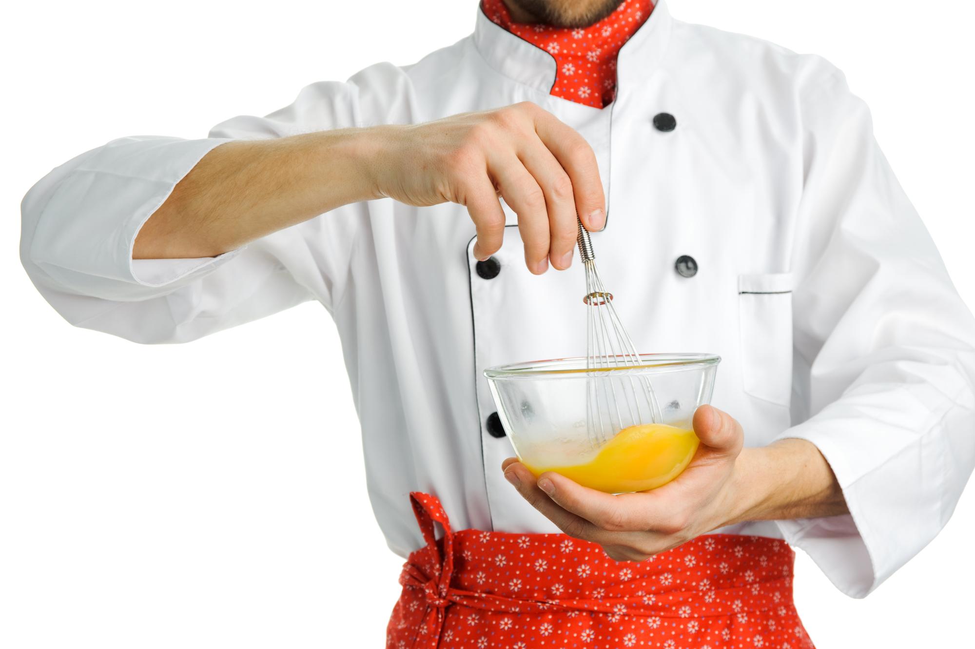 Workshop chef tasting sauce over stove
